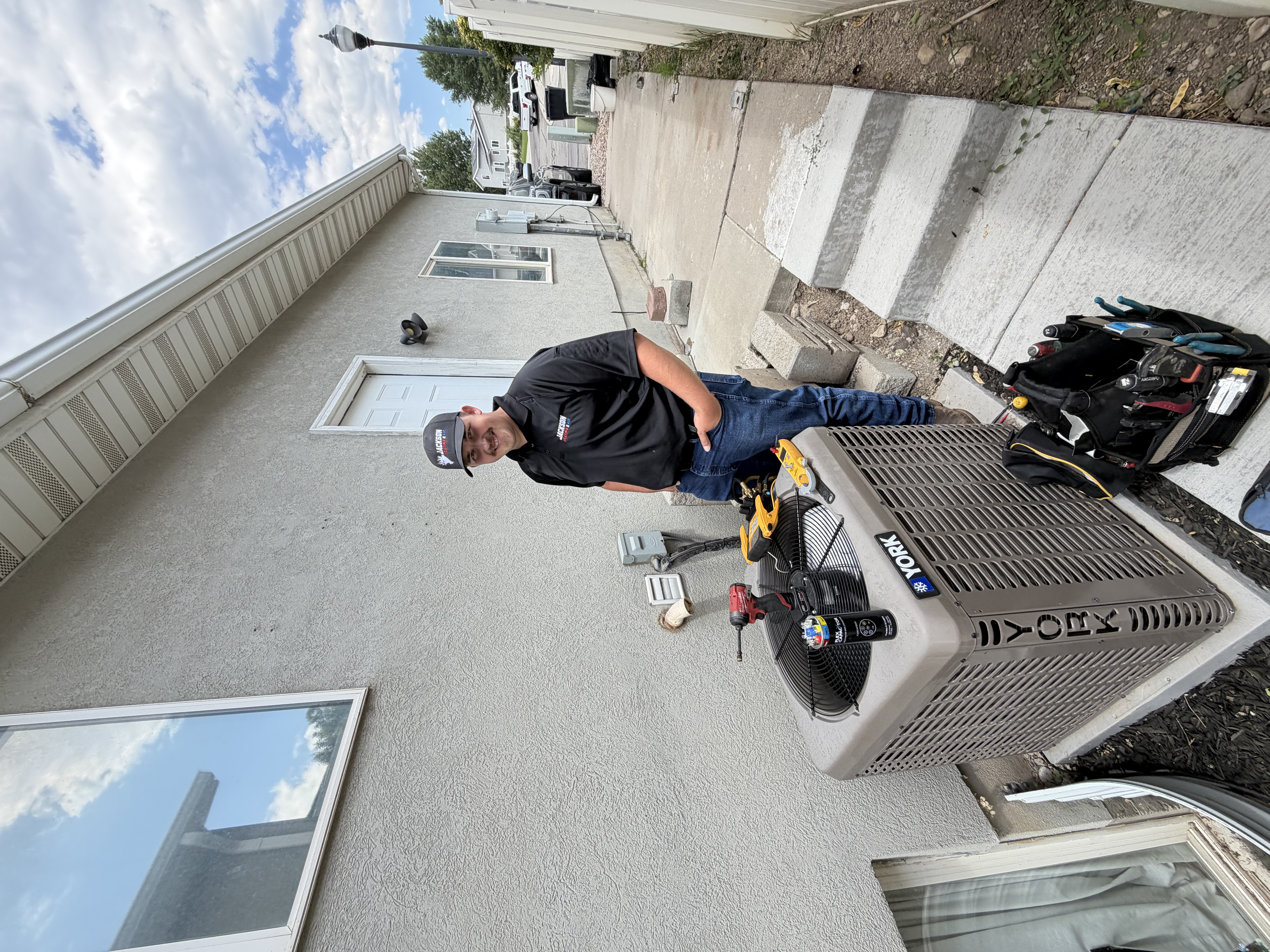 Jackson Heating & Air technician servicing a residential AC unit